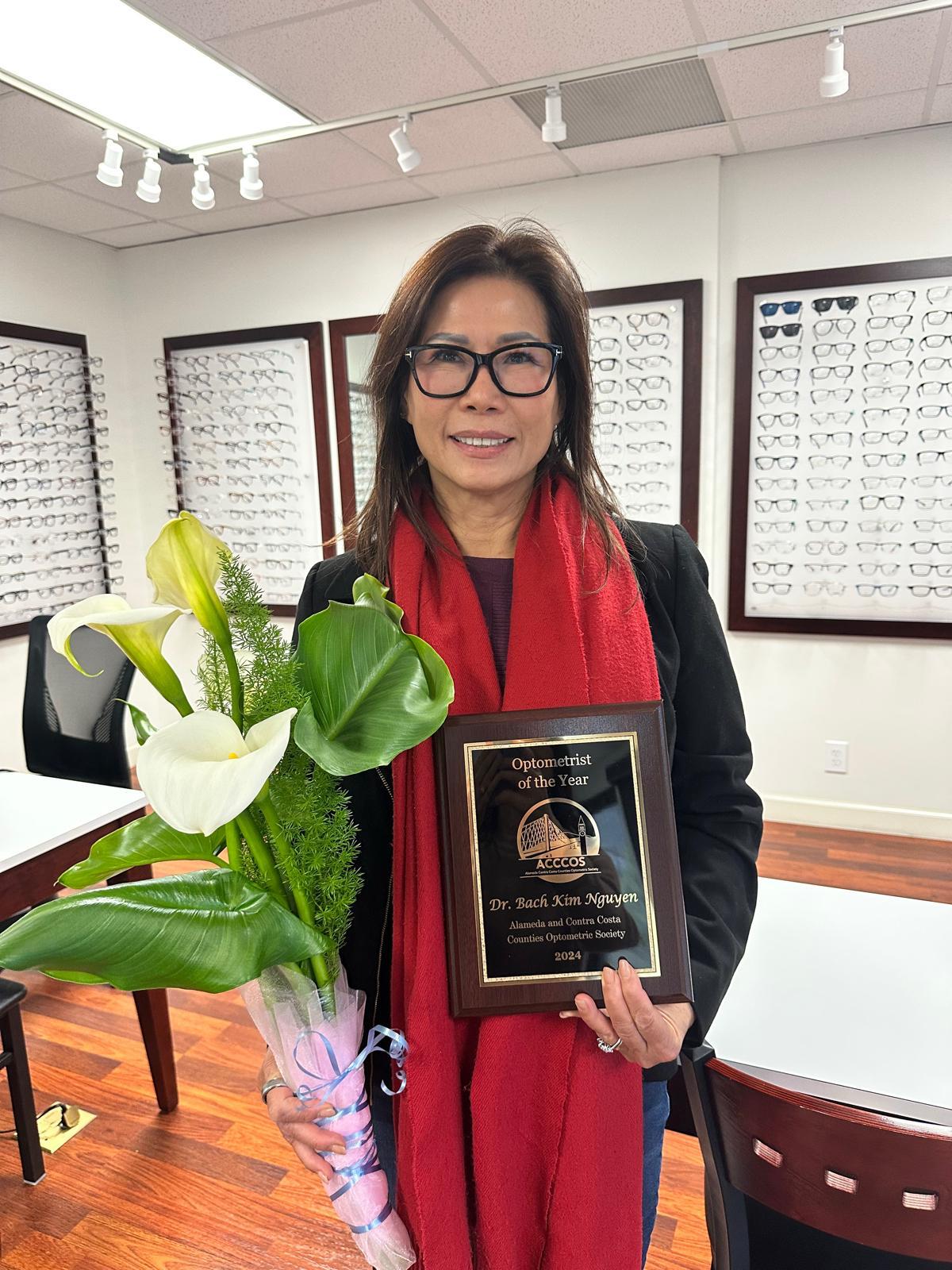 Dr. Bach Kim Nguyen holding her ACCCOS Optometrist of the Year plaque